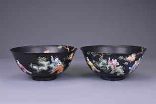 A PAIR OF CHINESE FAMILLE ROSE ENAMELLED BLACK GROUND PORCELAIN BOWLS, 20TH CENTURY. With apocryphal