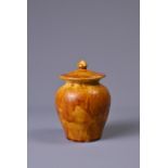 A CHINESE AMBER-GLAZED POTTERY JAR AND COVER. Of baluster form. Possibly Tang dynasty (618-907AD).