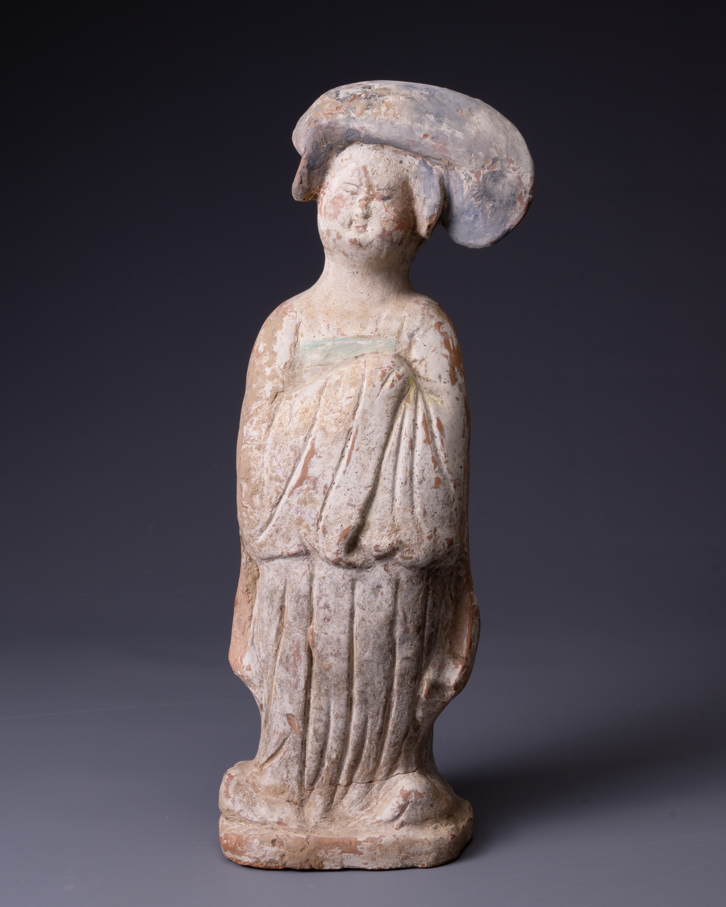 A CHINESE PAINTED POTTERY FIGURE OF COURT LADY, TANG DYNASTY (AD 618-907). Modelled standing wearing