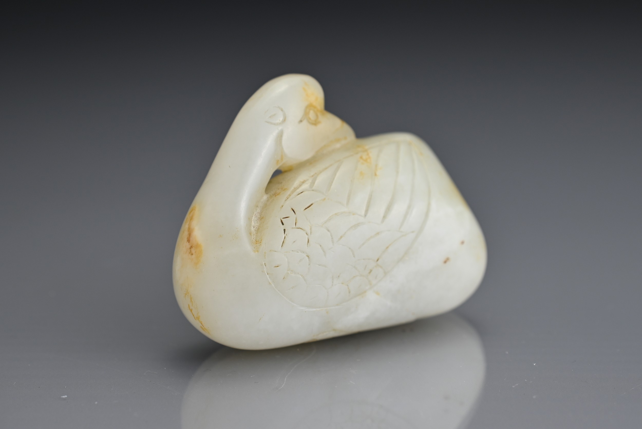 A CHINESE WHITE AND RUSSET JADE CARVING OF A CRANE, QING DYNASTY. Seated with its head turned to its - Image 3 of 5