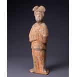 A CHINESE PAINTED POTTERY FIGURE OF COURT LADY, TANG DYNASTY (AD 618-907). Modelled standing wearing