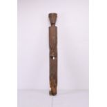 A TALL AFRICAN CARVED WOODEN FIGURE. A slender human figure with hands clasp in front of the