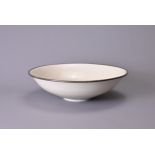 A CHINESE DING-STYLE BOWL WITH WHITE METAL RIM. Incised with a continuous band of flowers and