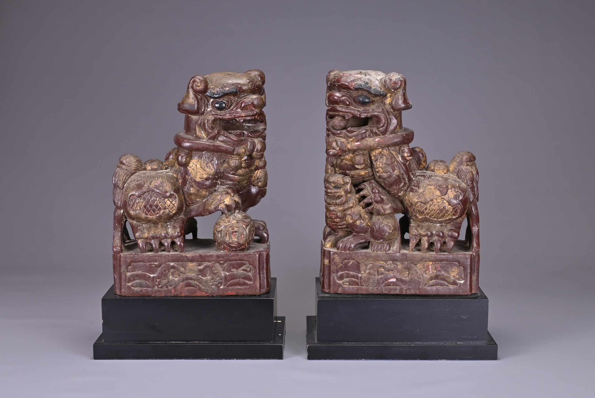 A PAIR OF CHINESE LACQUERED LION DOGS, 19/20TH CENTURY. Seated with its paw on a 'pierced ball', the