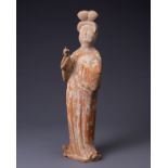 A CHINESE PAINTED POTTERY FIGURE OF COURT LADY, TANG DYNASTY (AD 618-907). Modelled standing wearing