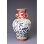 A CHINESE PORCELAIN FAMILLE ROSE RED-GROUND IMPERIAL-STYLE BALUSTER VASE, 20TH CENTURY. With