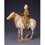 A CHINESE SANCAI GLAZED POTTERY MODEL OF A HORSE AND RIDER, TANG DYNASTY (AD 918-907). Modelled