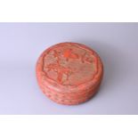 A CINNABAR LACQUER CIRCULAR BOX AND COVER. The cover carved with birds perched on flowering