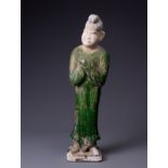 A CHINESE GREEN GLAZED POTTERY FIGURE OF AN ATTENDANT, TANG STYLE, PROBABLY 20TH CENTURY. Modelled