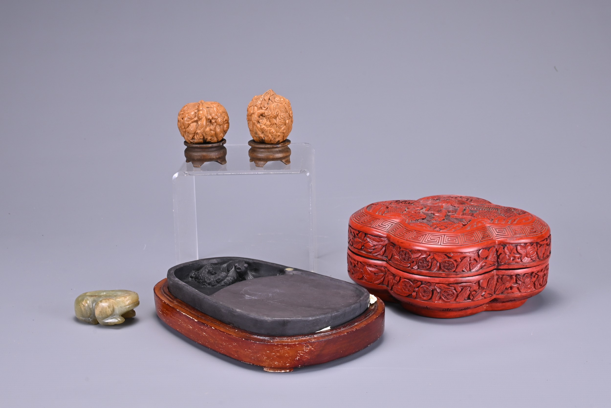 TWO CHINESE CARVED WALNUTS, A CINNABAR LACQUER BOX AND COVER, AN INKSTONE AND WOODEN CASE AND A