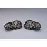 A PAIR OF CHINESE CARVED HORN FOO DOGS, QING DYNASTY. Each recumbent holding a 'pierced' ball.