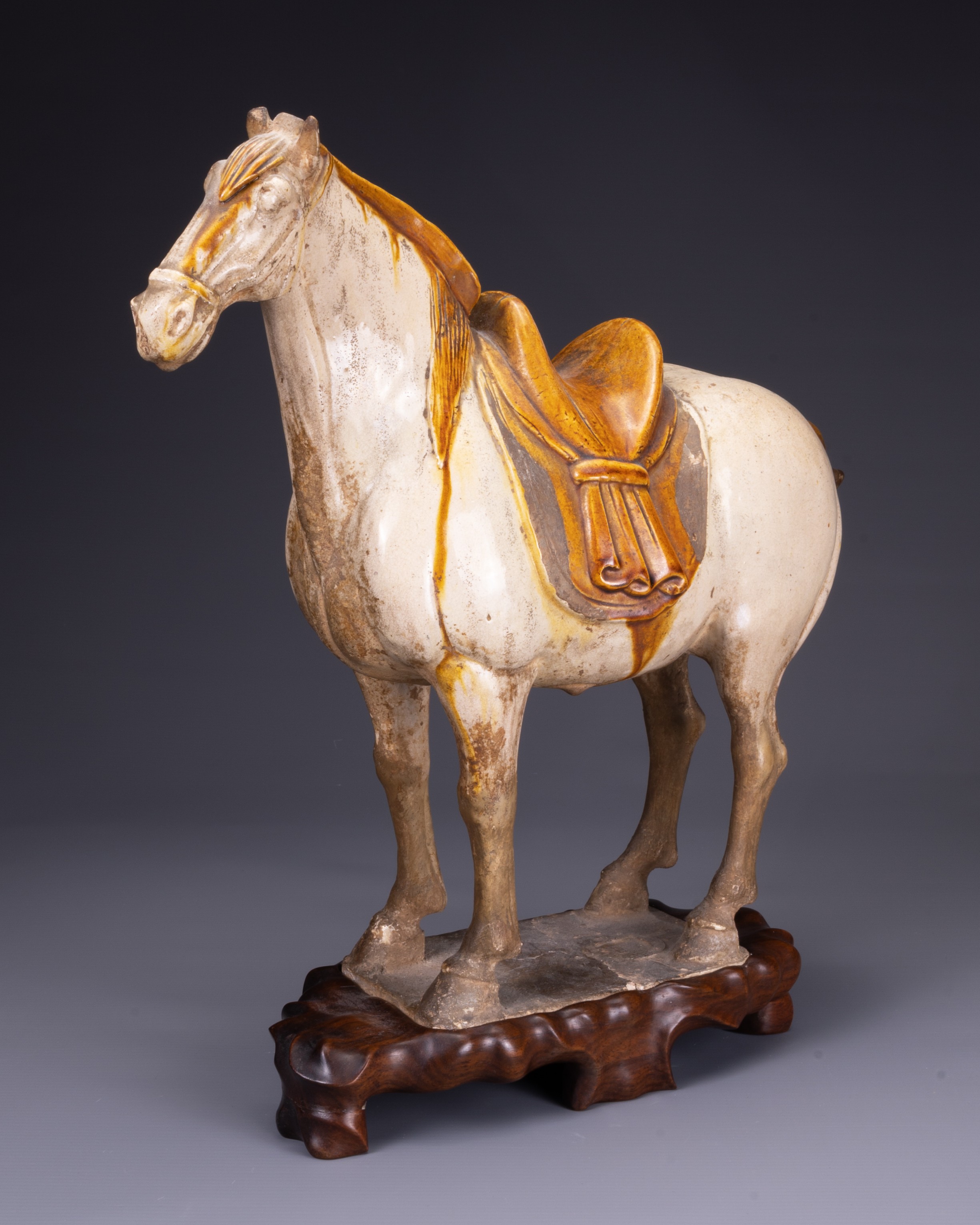 A CHINESE SANCAI GLAZED POTTERY MODEL OF A HORSE, TANG DYNASTY (AD 618-907). Modelled standing