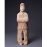 A CHINESE PAINTED POTTERY FIGURE OF AN ATTENDANT, TANG DYNASTY (AD 618-907). Modelled standing