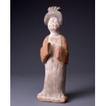 A CHINESE PAINTED POTTERY FIGURE OF COURT LADY, TANG DYNASTY (AD 618-907). Modelled standing wearing