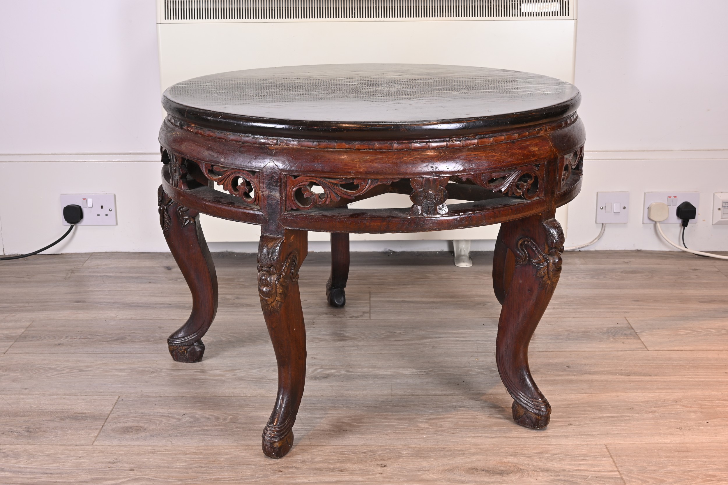 CHINESE 19TH/20TH CENTURY CIRCULAR HARDWOOD LOW TABLE, with black lacquer top and carved floral