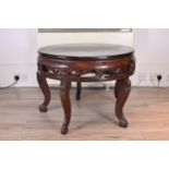 CHINESE 19TH/20TH CENTURY CIRCULAR HARDWOOD LOW TABLE, with black lacquer top and carved floral