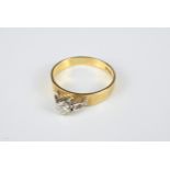 AN 18KT YELLOW GOLD AND DIAMOND SET RING. The brilliant cut diamond raised in a claw setting, on a