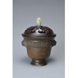 A CHINESE BRONZE CENSER AND COVER. In the form of a cup with lion mask handles and band of floral