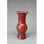 A CHINESE SANG-DE-BOEUF PORCELAIN GU-FORM BEAKER VASE. Covered in a dark red speckled glaze thinning