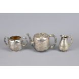 A SILVER PLATED TEA SET, 19TH CENTURY. To include a teapot, sugar pot and creamer. Each decorated