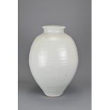 A WHITE GLAZED CERAMIC VASE, 20TH CENTURY. Heavily potted ovoid form with short neck and rolled