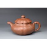 A 20TH CENTURY CHINESE YIXING STONEWARE TEAPOT AND COVER. Of lobed form, incised with flowers, and