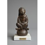 A 20TH CENTURY JAPANESE BRONZE MODEL OF A BOY. Seated crossed legged on a ball, wearing a