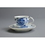 A JAPANESE LATE MEIJI PERIOD (1869-1912) BLUE AND WHITE PORCELAIN TEACUP AND SAUCER. With knotted