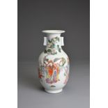 A CHINESE FAMILLE ROSE PORCELAIN VASE, 20TH CENTURY. Of baluster form with tubular handles decorated