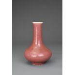 A CHINESE PEACHBLOOM GLAZED PORCELAIN BOTTLE VASE, QIANLONG MARK. Compressed pear shaped body with