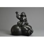 A 20TH CENTURY JAPANESE BRONZE MODEL OF DAIKOKUTEN. Cast seated on a sack, holding aloft a mouse,