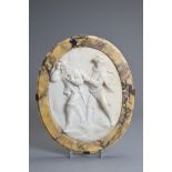 A CARVED MARBLE OVAL PLAQUE. The white marble plaque carved in the Victorian style in high relief
