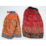 TWO VINTAGE INDIAN EMBROIDERED COTTON AND MIRROR WORK SKIRTS. The first orange ground, embroidered