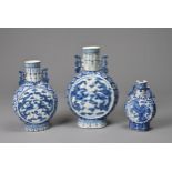 THREE CHINESE BLUE AND WHITE PORCELAIN MOON FLASKS, 19TH CENTURY. Of graduating sizes decorated with