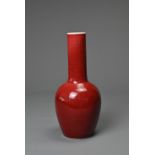 A CHINESE RED GLAZED PORCELAIN BOTTLE VASE, KANGXI MARK. Ovoid body leading into to a tall