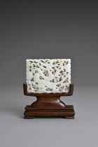 A CHINESE WHITE JADE PLAQUE ON STAND, 19/20TH CENTURY. Carved and pierced featuring a dragon on