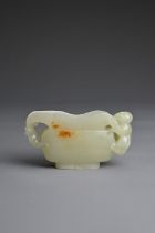 A CHINESE CARVED PALE CELADON JADE CUP. Pale celadon colour with russet patches, featuring a boy