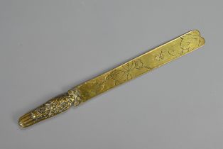 A JAPANESE Meiji period (1868-1912) BRASS PAPER KNIFE. The gourd shaped handle cast with flowers and