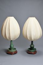 TWO CHINESE GREEN GLAZED CERAMIC CONVERTED CANDLESTICK LAMPS. Each candlestick with drip tray