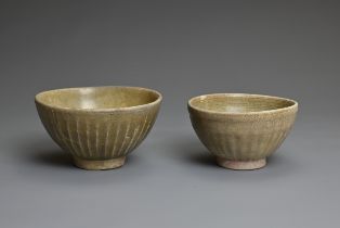 TWO THAI CELADON POTTERY BOWLS, SAWANKHALOK 14/16TH CENTURY. Each of rounded form rising from a