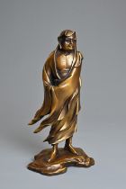 A 20TH CENTURY JAPANESE GILT BRONZE FIGURE OF DARUMA AFTER KOUN TAKAMURA (1852-1934). Cast