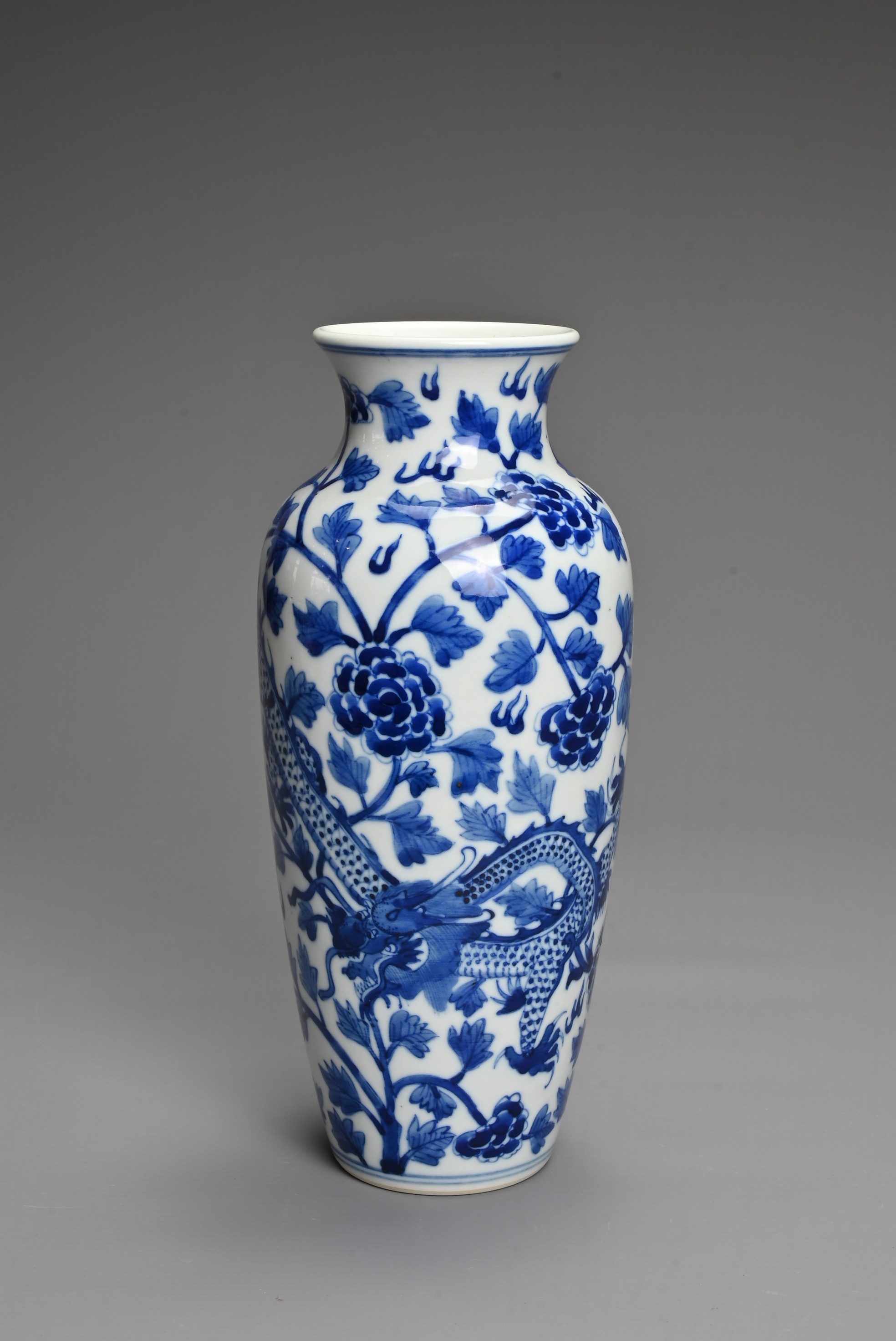 A CHINESE BLUE AND WHITE PORCELAIN VASE. Decorated with a dragon and leafy peony scrolls with flat