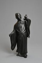 A 20TH CENTURY JAPANESE BRONZE OF A FIGURE OF A SCHOLAR HOLDING ALOFT A BIRD. Cast standing in a