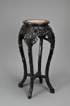 A CHINESE HARDWOOD JARDINIERE STAND, 19/20TH CENTURY. Carved in relief with s shaped faux bamboo