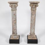 Pair of marble column pedestals on a black marble base