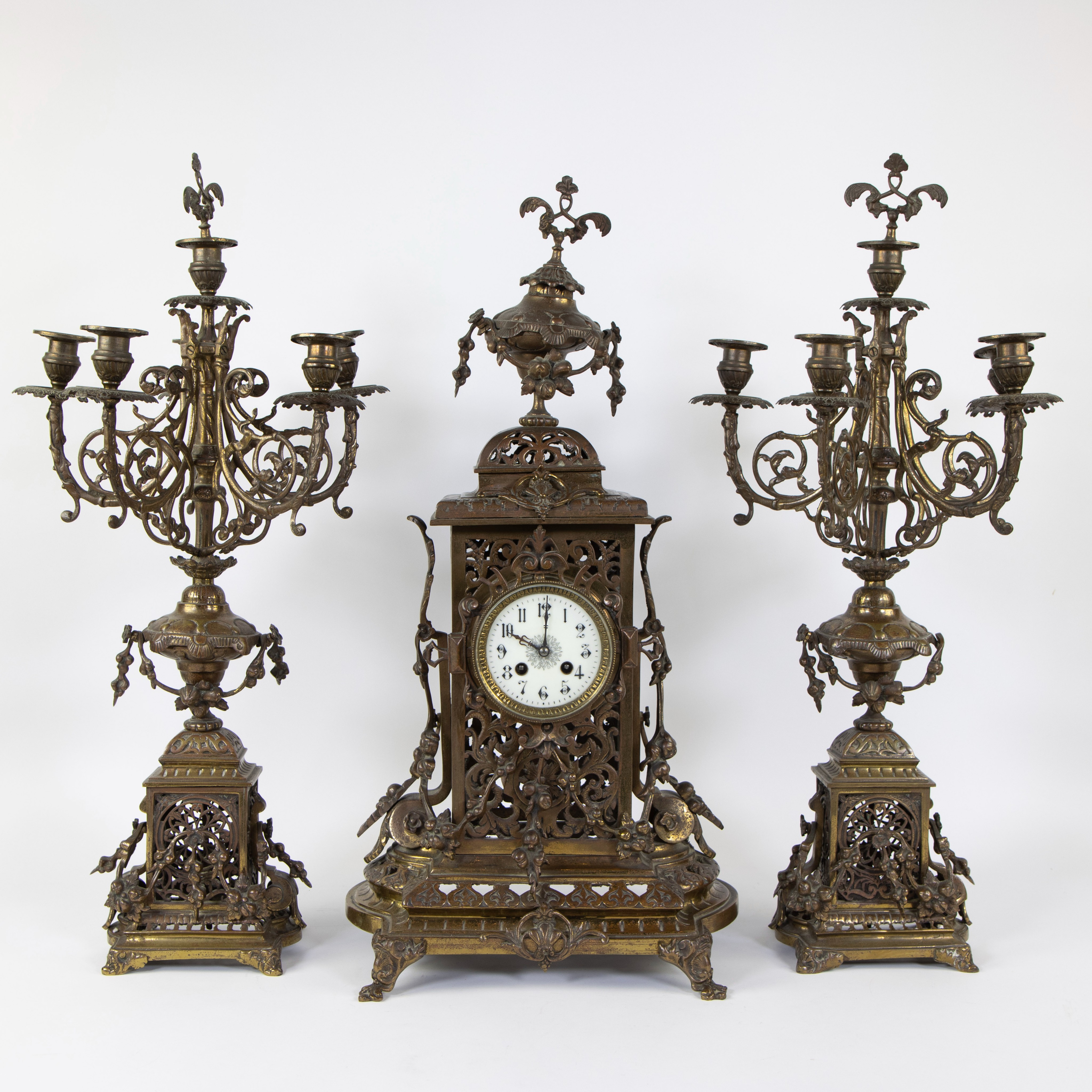 A Napoleon III style brass clock set comprising a mantel clock and two candlesticks.