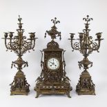 A Napoleon III style brass clock set comprising a mantel clock and two candlesticks.