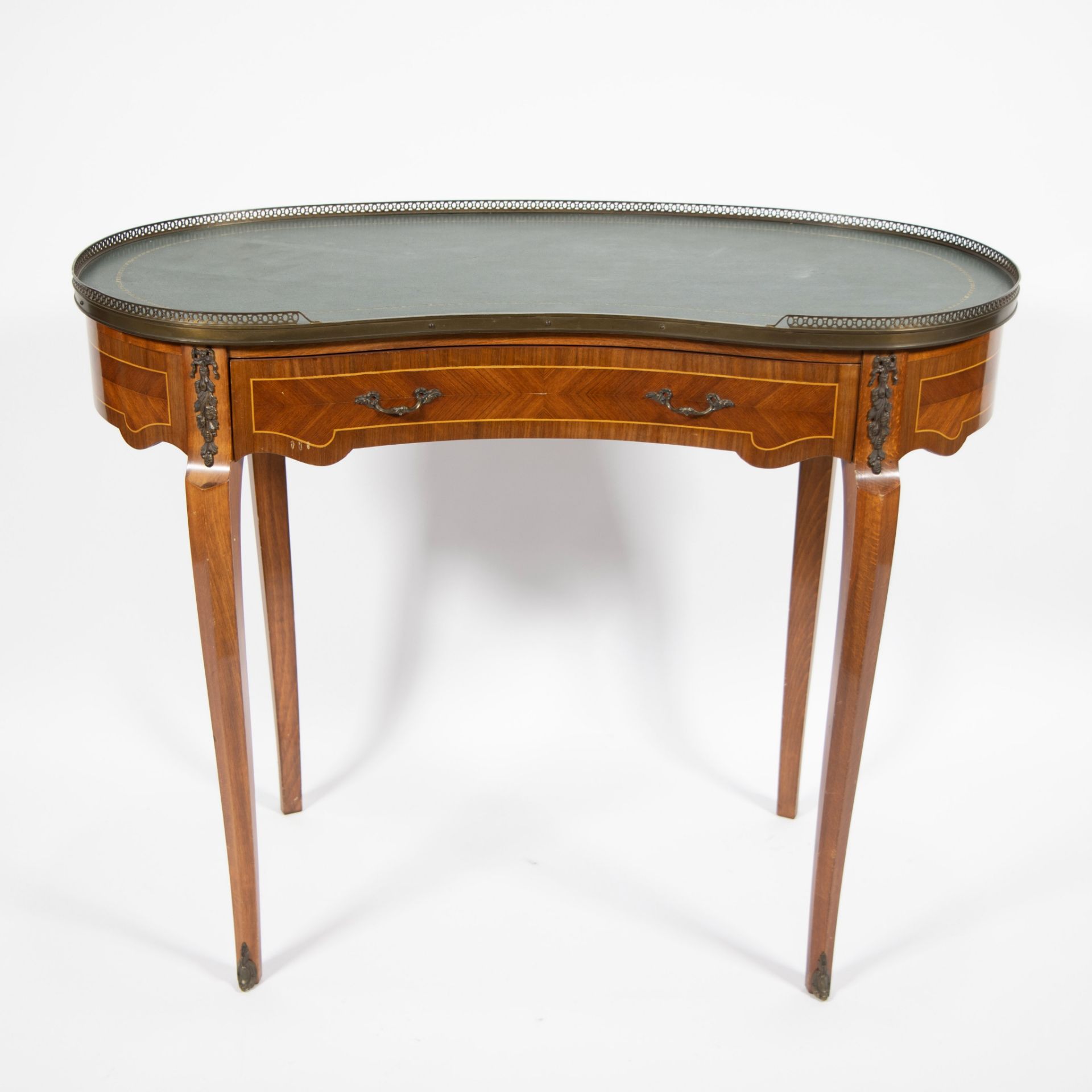 Large kidney-shaped table with drawer, raised edge in brass and green leaf in imitation leather