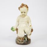A ceramic figure of a seated child, Karlsruher Majolika, marked