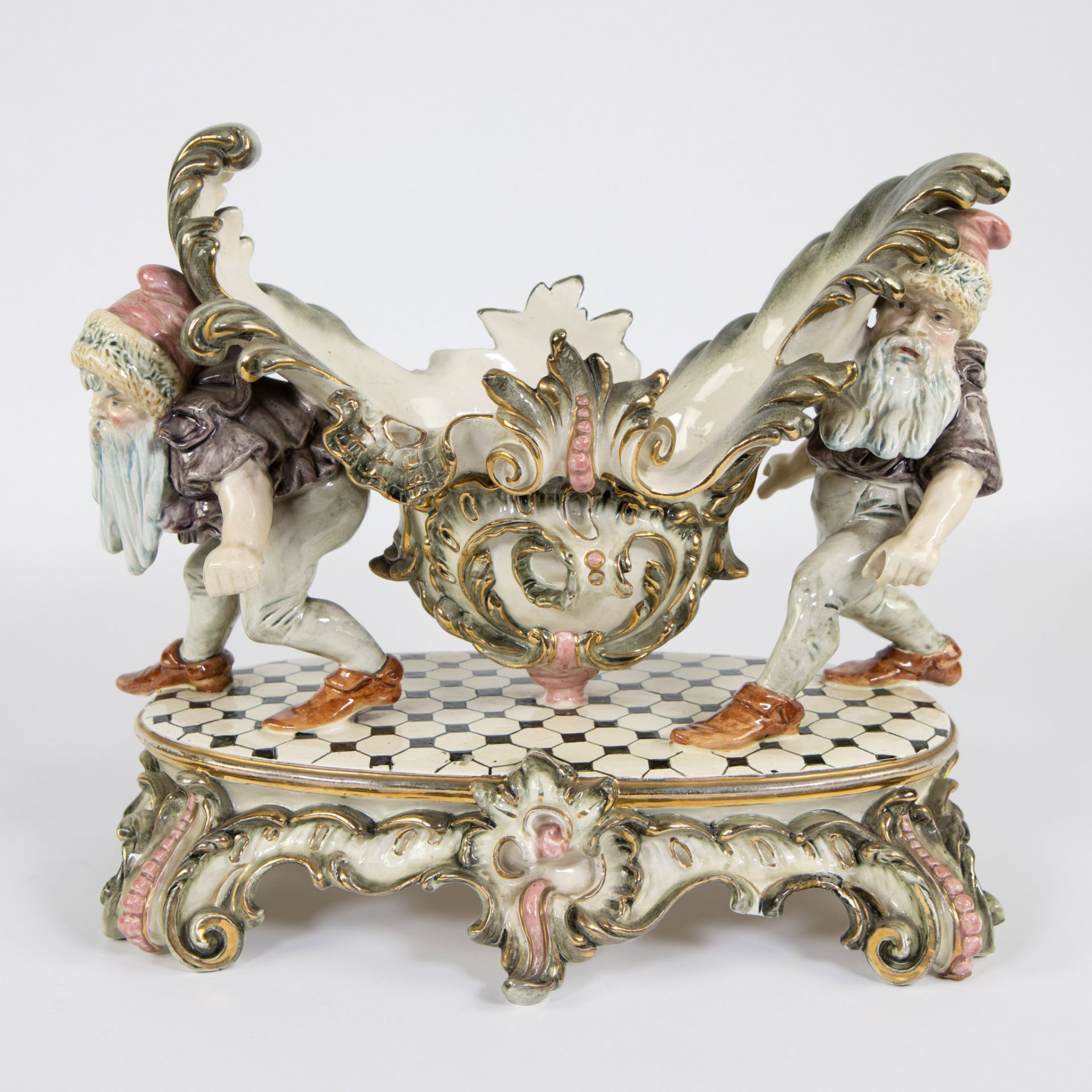 Polychrome porcelain center piece depicting a coupe carried by 2 gnomes